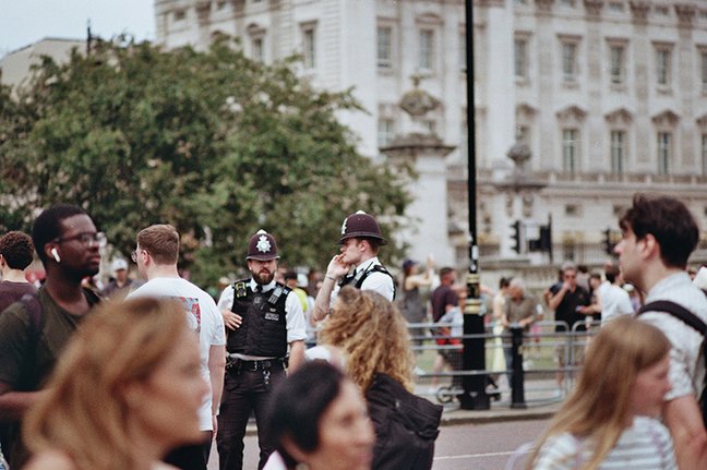 People and police officers near a grand building