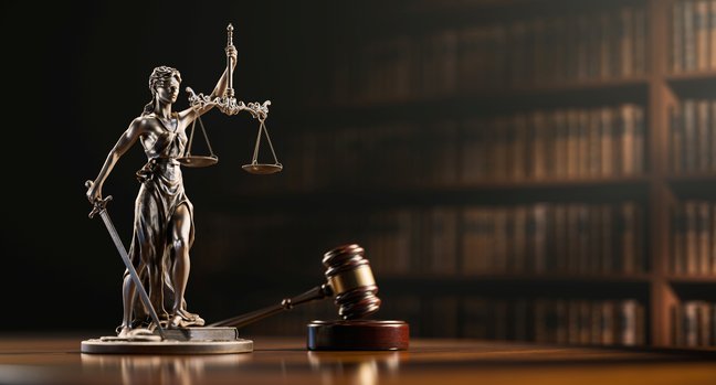 Legal Concept: Themis is the goddess of justice &the judge's gavel hammer as symbol of law &order on the background of books