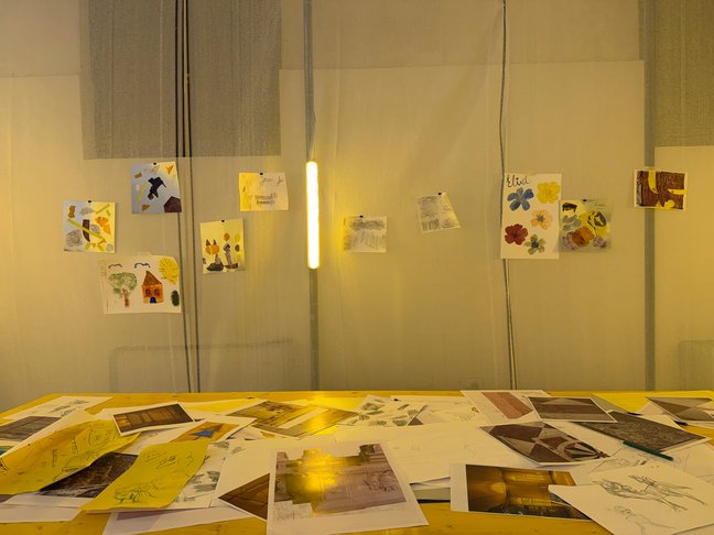 Children's artwork displayed on a wall above a table